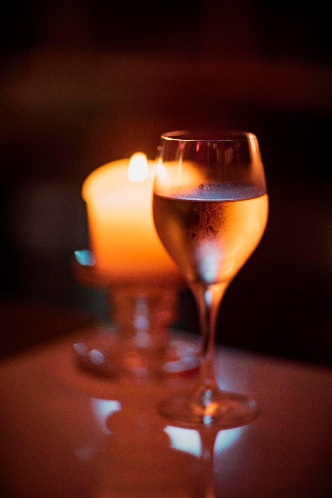 Wine glasses lit by candlelight