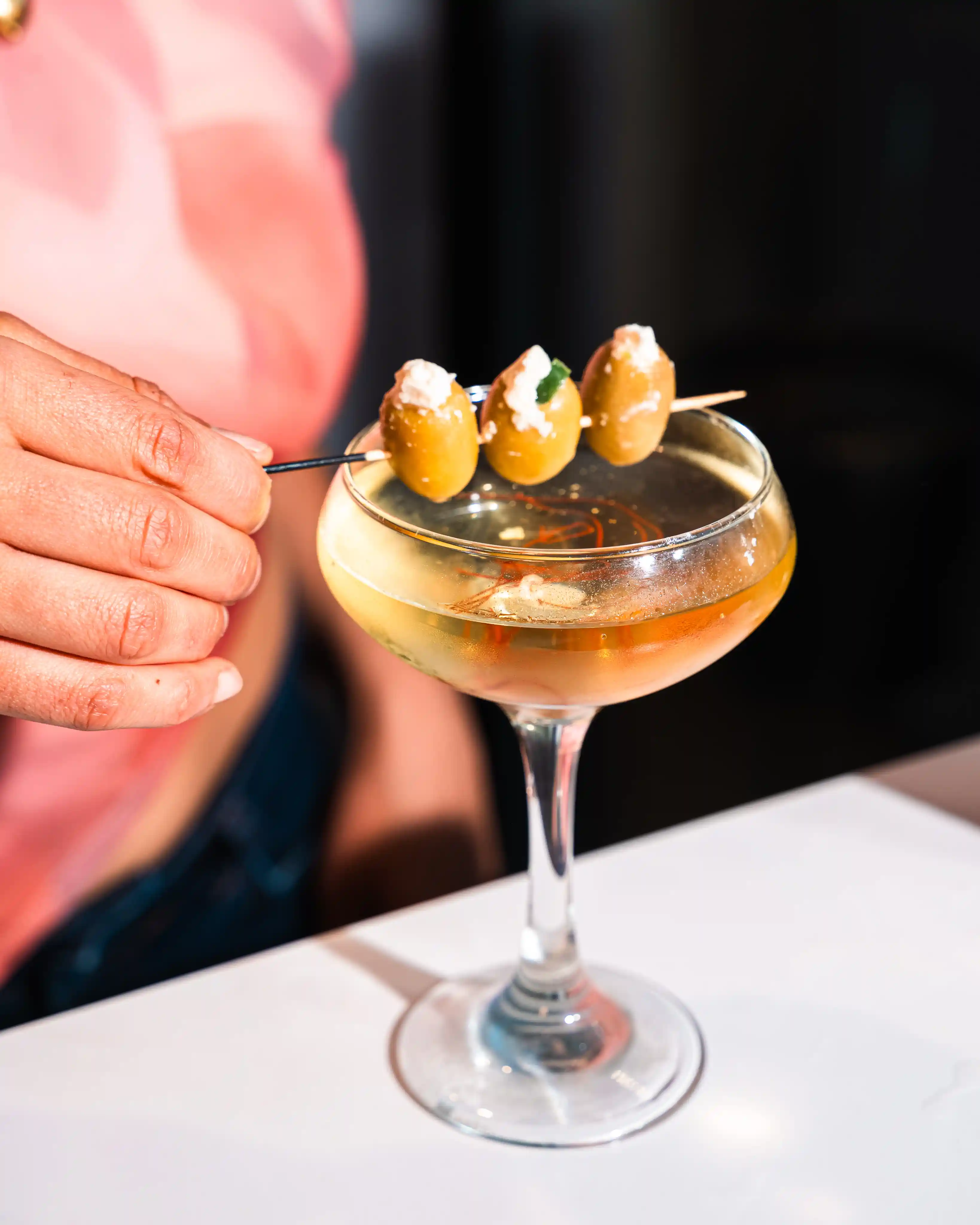 Overhead view of an amber cocktail on green surface