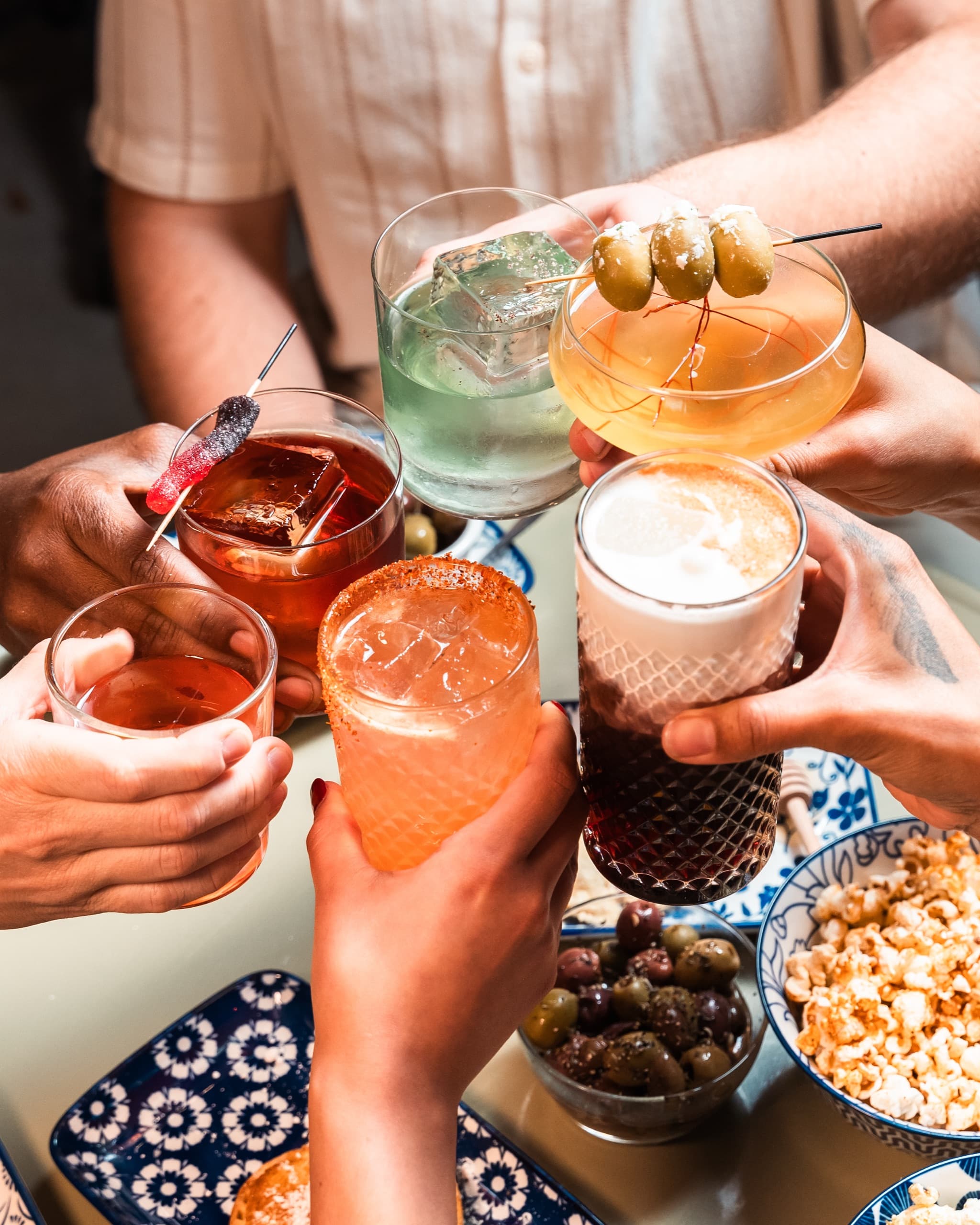 Friends toasting with colorful cocktails
